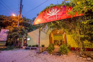 una tabla de surf está colgando en el lateral de un edificio en Indra Inn, en Playa Grande