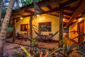 eine Außenansicht eines Hauses mit Bäumen und Pflanzen in der Unterkunft Indra Inn in Playa Grande