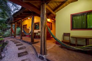 a porch with a hammock in a house at Indra Inn in Playa Grande +26 photos