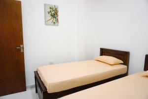 1 dormitorio con 2 camas y una foto en la pared en White Rose Hostel en Kandy