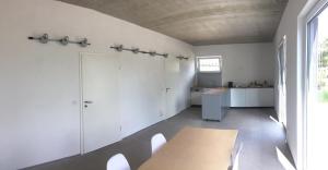 a kitchen with white walls and a table and chairs at Designer Studio Geestland in Langen