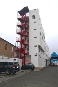 un edificio blanco alto con andamios. en Gran Caral Hotel en Barranca