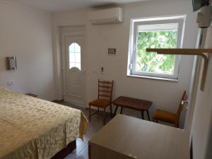 - une chambre avec un lit, deux chaises et une fenêtre dans l'établissement Mejak & Bordon, à Sečovlje