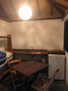 Zimmer mit einem Tisch, einem Waschbecken und einem Schreibtisch in der Unterkunft Estalagem Engenho de Serra in Itamonte