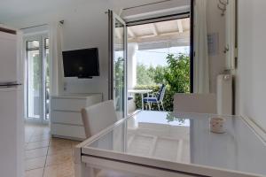 a kitchen and living room with a view of a patio at Apartments Del Sole in Nerezine