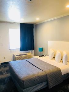 a hotel room with a bed and a window at BridgePoint Inn Daly City in Daly City