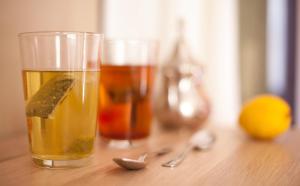 dos vasos de té y un limón sobre una mesa de madera en AbraCadabra Suites, en Madrid