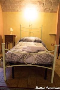 una cama con una luz encima en Lo Sfizio B&B, en Cupramontana