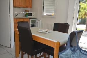 a dining room table with chairs and a kitchen at Le Braz Saint Lunaire in Saint-Lunaire