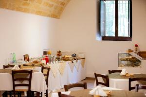 a dining room with tables and chairs and a window at Il Carmine Dimora Storica in Erice