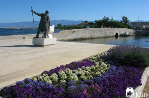 a statue of a man standing next to flowers at Vacation Home Katarina in Nin