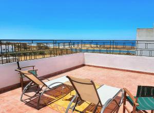 a patio with chairs and a table on a balcony at Maison de la Lagune in Oualidia