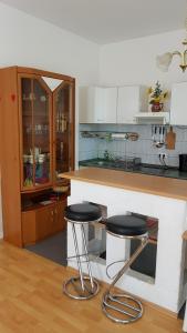 a kitchen with two bar stools in front of a counter at Apartment Karin in Dresden