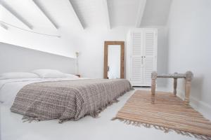 - une chambre blanche avec un lit et un tapis dans l'établissement Akassa Alojamientos Bioclimaticos en las Hurdes, à Pinofranqueado