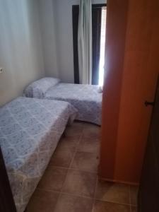 1 Schlafzimmer mit 2 Betten und einem Fenster in der Unterkunft PERGAR DESCANSO-15 minutos Playa-Motril Ferry in Acebuches