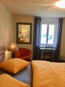 a bedroom with a bed and a chair and a window at Casa Ortensia in Magadino