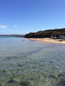 a beach with people swimming in the water at Bungalow33 Benllech in Benllech