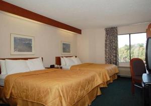 a hotel room with two beds and a window at Baymont by Wyndham Mooresville in Mooresville