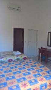 um quarto com uma cama com uma colcha colorida em Hotel CZ em Santa Cruz, Huatulco