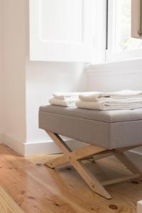 een stapel handdoeken zittend op een bed in een kamer bij Destino Lisboa Apartments in Lissabon
