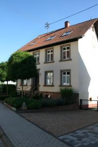 a house with a red roof on a brick road at Ferienwohnung Atrium in Niederlinxweiler