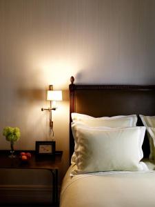 a bed with a white comforter and pillows at The Greenwich Hotel in New York