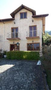a house with a stone driveway in front of it at Aconchego da Serra in Teresópolis