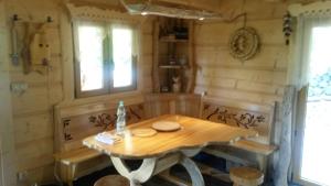 une table en bois et des bancs dans une pièce avec une table dans l'établissement Kaszubska Górska Chata, à Bytów