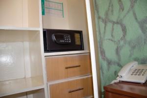 a kitchen with a microwave and a telephone in a room at Ash White Hotel in Nairobi