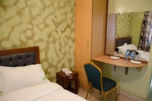 Postel nebo postele na pokoji v ubytování Ash White Hotel