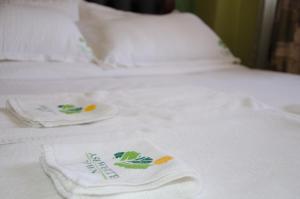 Una cama con toallas blancas encima. en Ash White Hotel, en Nairobi