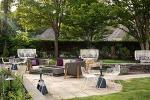 a patio with tables and chairs in a yard at The Richard, The Edgartown Collection in Edgartown