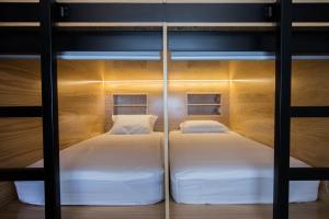 two beds in a bunk bed room with lights at GiG Capsule Hostel in Ericeira