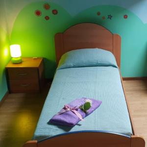 un letto con una coperta viola e una bambola sopra di Appartamento LUCE a Volpiano