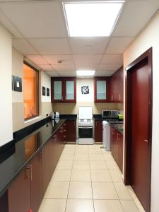 a large kitchen with brown cabinets and a skylight at JBR, Bahar 1 in Dubai