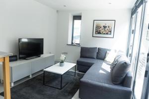 a living room with a couch and a tv at Gillespie House in Edinburgh