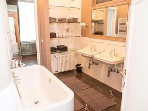 
a bathroom with a tub, sink, and toilet at One Room in Ostend
