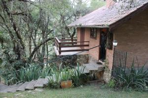 een klein bakstenen huis met een trap en een veranda bij Chales Chez Nous in Monte Verde