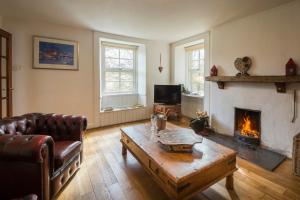a living room with a couch and a fireplace at The Ferry House Cottage in Aberfeldy