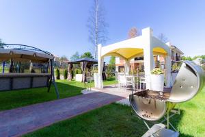 a gazebo with a table and chairs in a yard at Vila Estate in Palanga