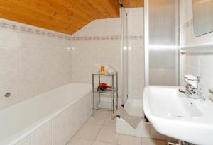 a white bathroom with a tub and a sink at Bauernhof Madlener Claudia in Schoppernau +12 photos