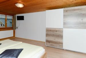 a bedroom with a bed and a tv on a wall at Bauernhof Madlener Claudia in Schoppernau