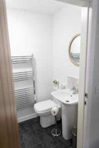 a white bathroom with a toilet and a sink at The Forge Bed & Breakfast in Auchterarder