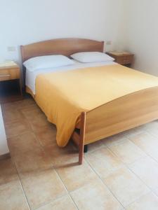 una camera da letto con un letto con una coperta gialla sopra di Eremo dei Poeti a Mosciano SantʼAngelo