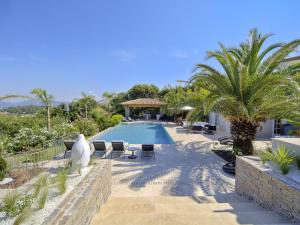 un complejo con piscina y palmeras en Villa Orchard, en Saint-Tropez