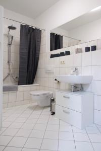 La salle de bains blanche est pourvue d'un lavabo et de toilettes. dans l'établissement Ferienwohnung am Völkerschlachtdenkmal, à Leipzig