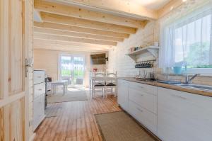 a kitchen with white cabinets and a dining room at Willa Mycyny oraz domki in Mycyny