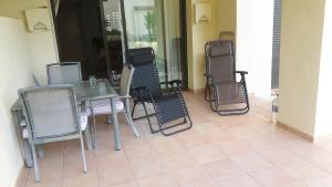 une table et des chaises assises sur une terrasse dans l'établissement Casa Rosie, à Los Alcázares