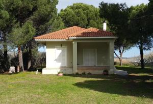 une petite maison blanche dans une cour arborée dans l'établissement Villa Sunny Day, à Marathon