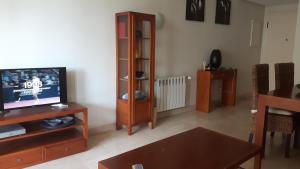 salon z telewizorem i stołem w obiekcie Casa Rosie w mieście Los Alcázares